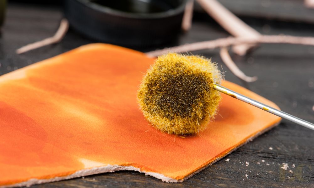 close up of applying leather dye to vegetable tanned leather using a wool dauber applicator