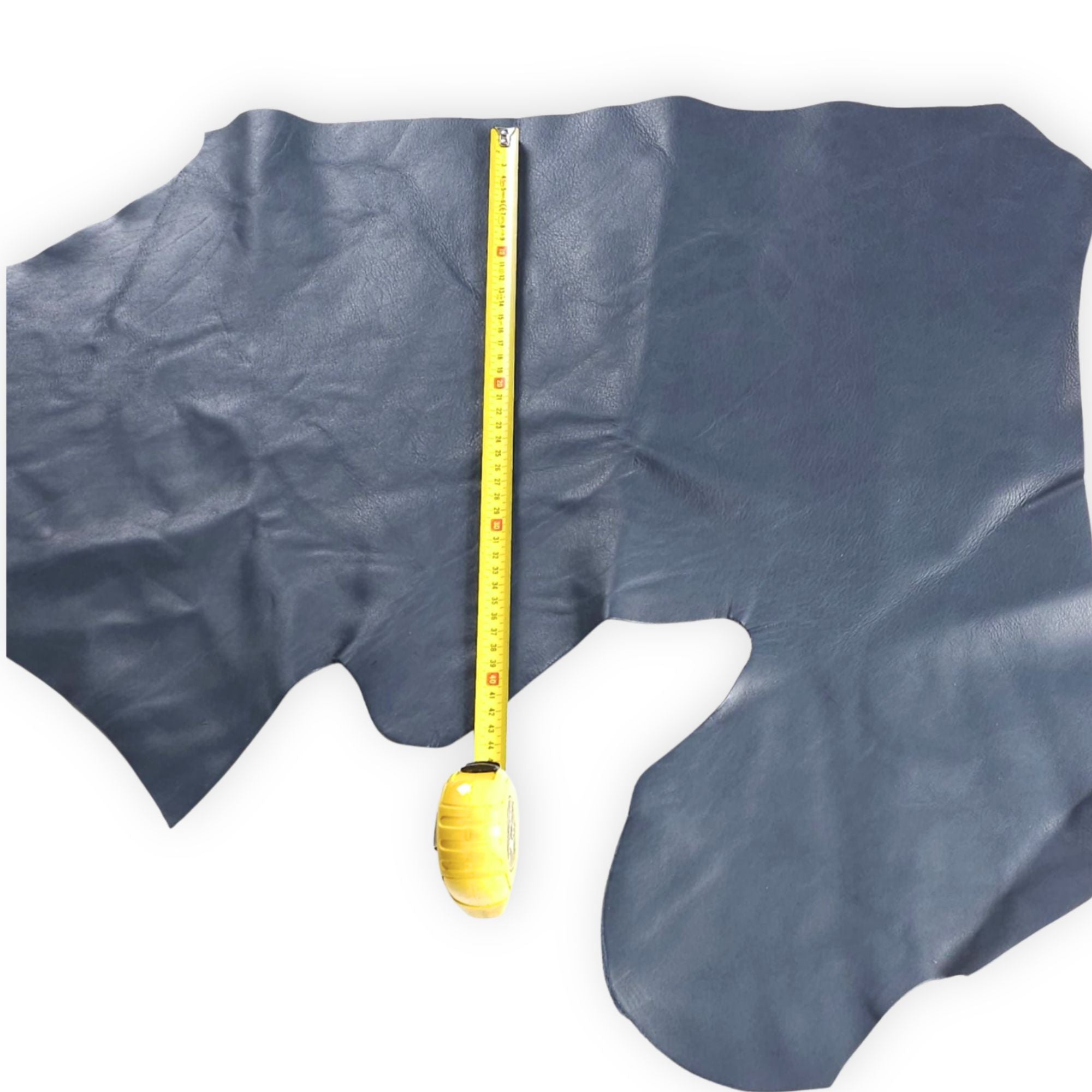 Blue grey cowhide leather piece with a tape measure for size reference