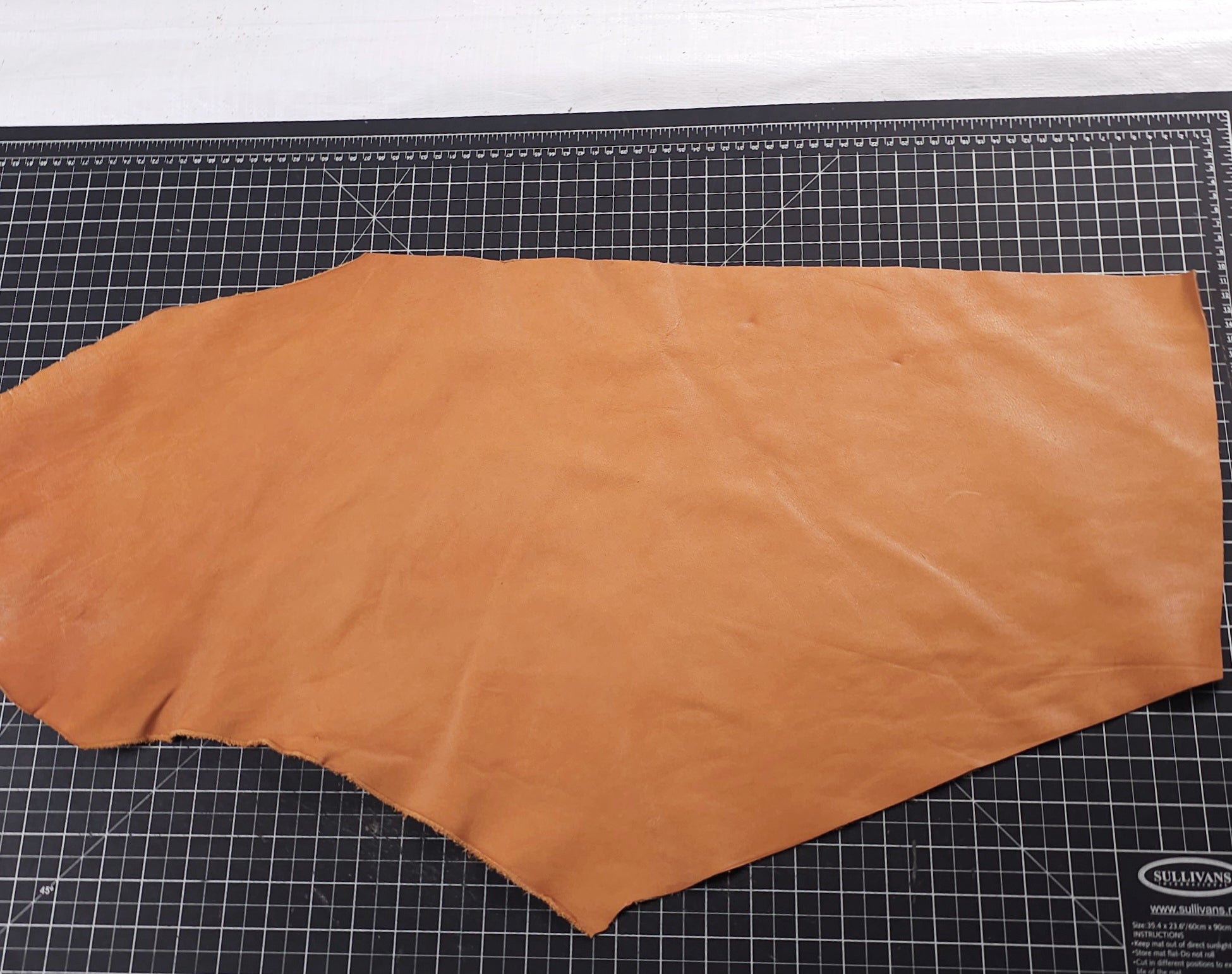 Saddle tan veg tan leather piece measured horizontally