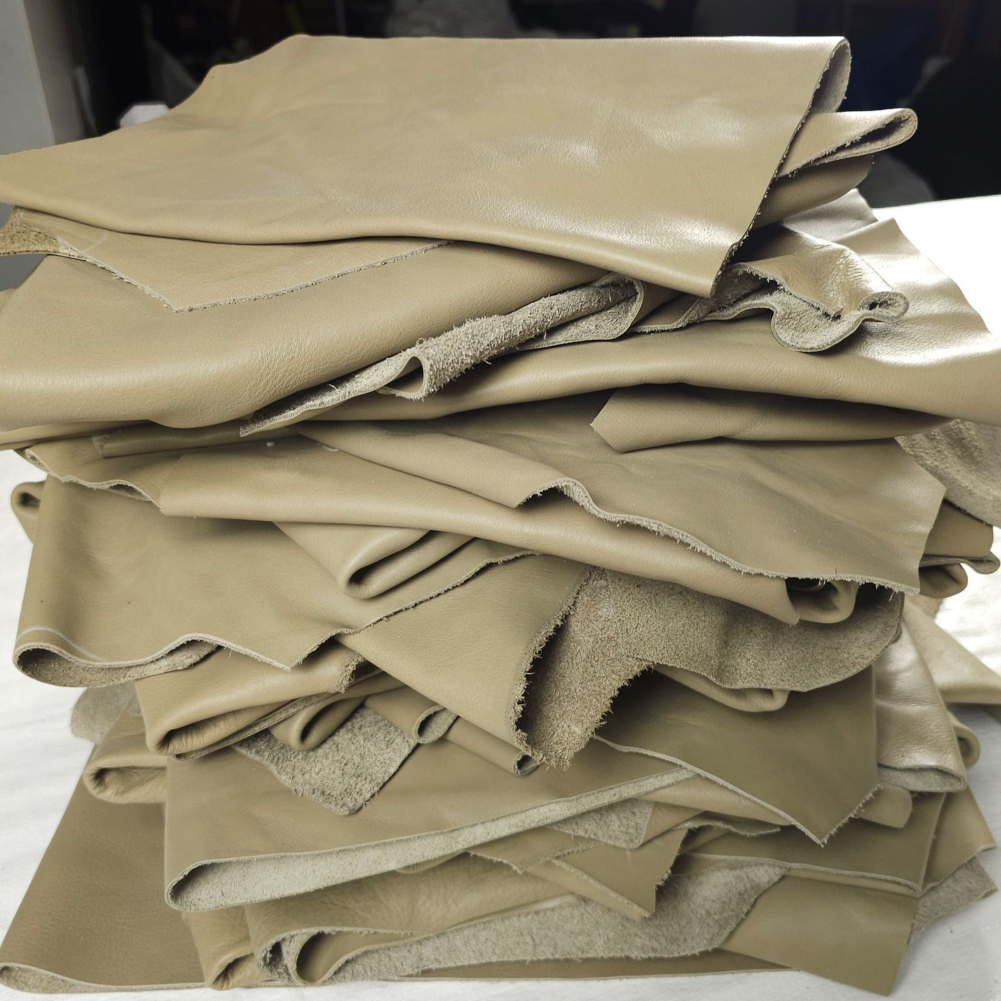 Sage green leather remnants stacked in 1–2 sq ft pieces