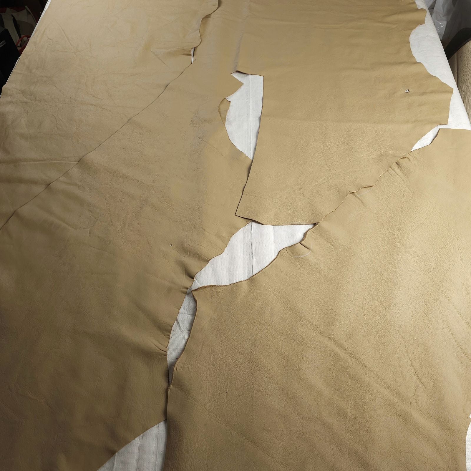 Beige solid colour leather pieces laid flat