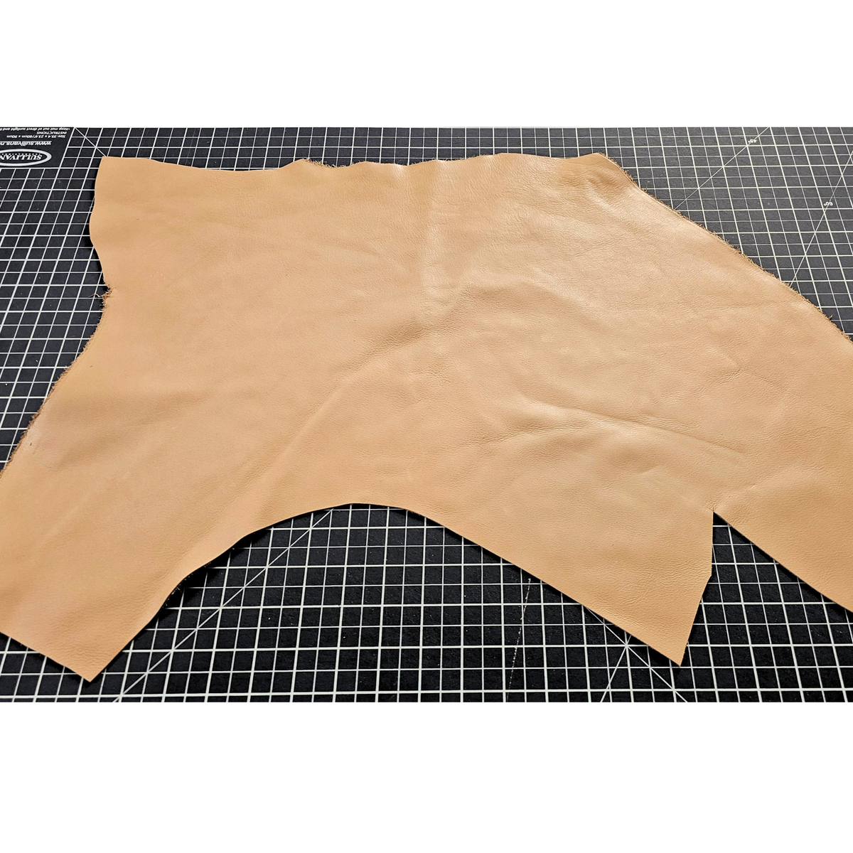 Tan full-grain cowhide leather piece showing natural shape and grain