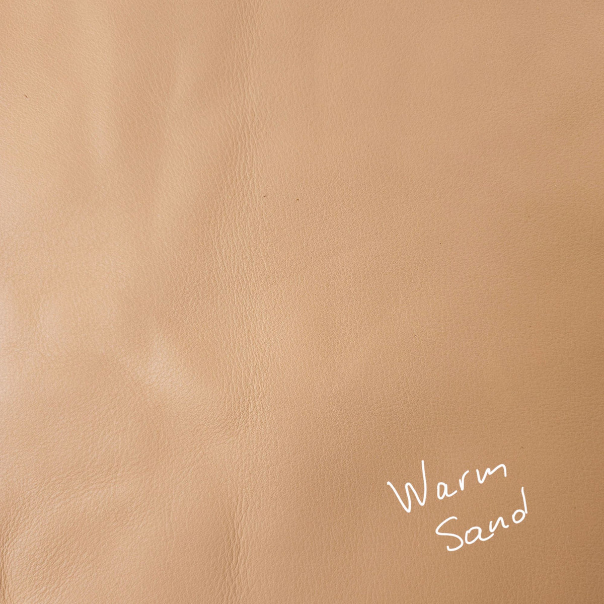 Warm sand cowhide leather piece showing natural tonal variation
